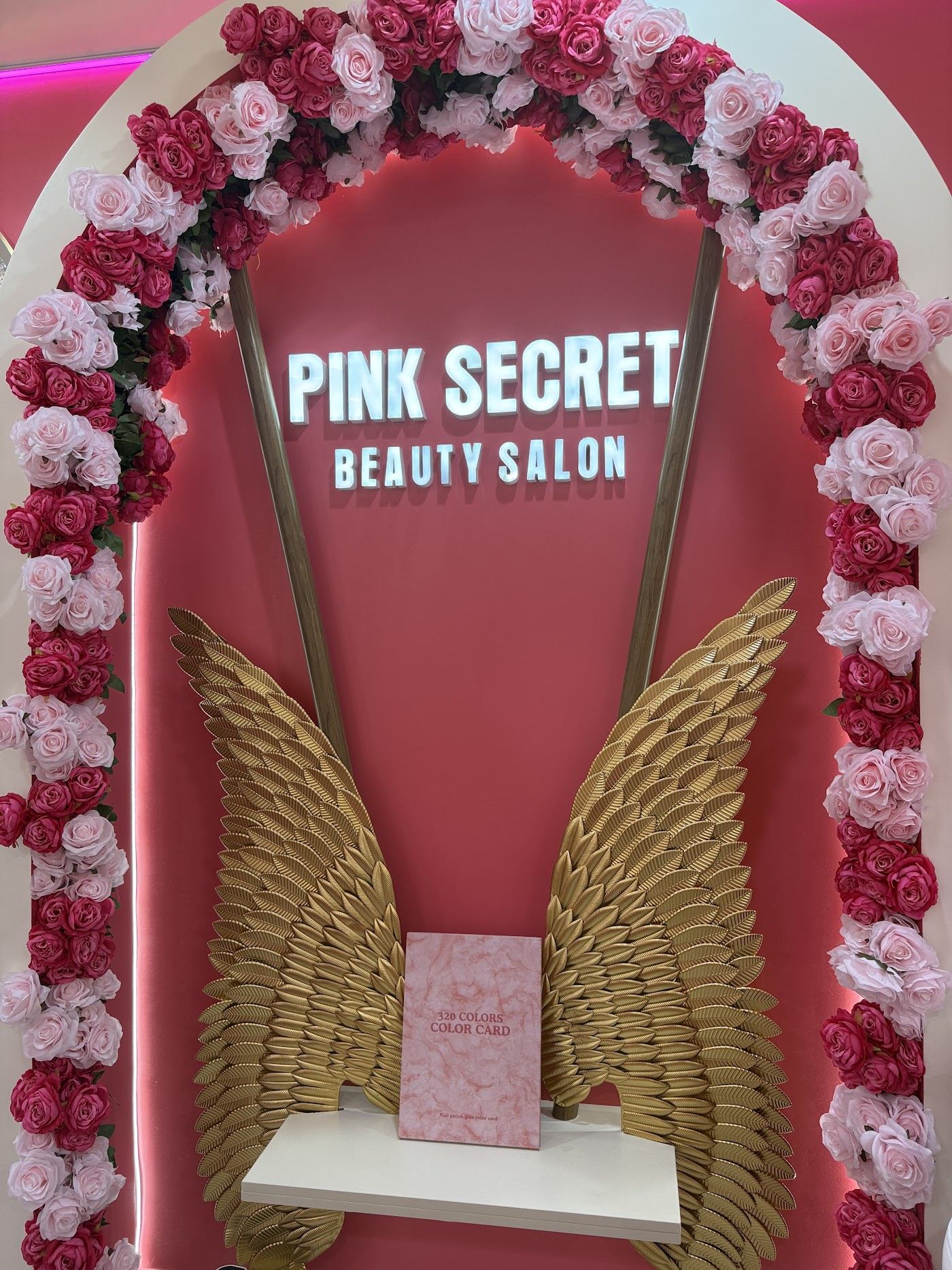 Pink Secret Beauty Salon sign with rose arch and golden wings